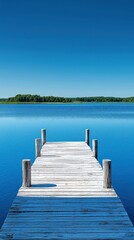 Fototapeta premium Serene Rustic Wooden Pier Under Clear Blue Summer Sky