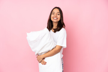 Young woman in pajamas isolated on pink background with arms crossed and looking forward