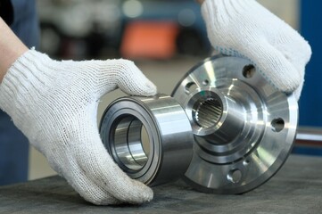 Auto parts. Car service. The suspension of the car. The bearing and wheel hub are in the hands of an auto mechanic. Check the compatibility of parts before installation.