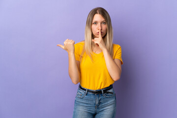 Fototapeta premium Young blonde woman isolated on purple background pointing to the side and doing silence gesture