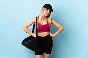 Young sport woman with sport bag isolated on blue background angry