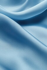 Fototapeta premium Smooth Silk Texture: Soft, flowing blue silk fabric cascades in graceful waves, creating a luxurious and elegant texture, perfect for fashion, design, and backgrounds.