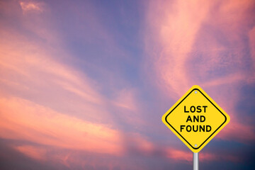 Yellow transportation sign with word lost and found on violet color sky background