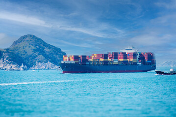 Large cargo container ship at sea, she is fully loaded with colorful containers.