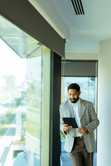 Fototapeta premium Professional man contemplating future while holding tablet in modern office setting