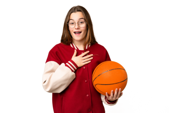 Teenager girl playing basketball over isolated chroma key background surprised and shocked while looking right