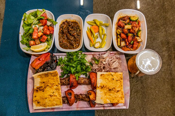 Meal in Turkey - dish of Adana kebab with side dishes and ayran drink