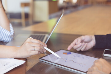 close up ceo businessman hand use stylus pen to point on dashboard screen tablet device for ask and share idea or consulting with businesswoman partner for business teamwork concept