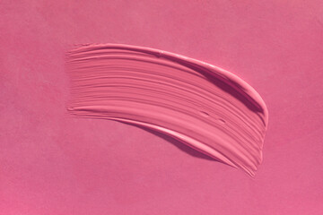 Lipstick or creamy bluster smudge swatch isolated on pink background