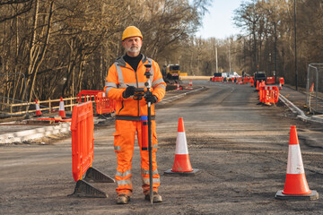 Construction worker surveys road roadworks