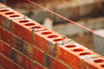 Construction of brick wall using red clay bricks