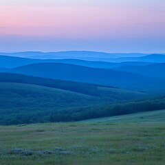 Layers of rolling hills and mountains at sunrise or sunset
