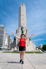 Mujer turista, con sombrero y mochila, descubriendo y asombrándose en el Monumento Nacional a la...