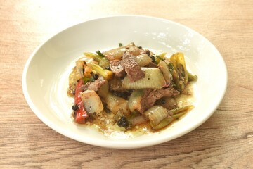 spicy stir fried ostrich meat with onion and black pepper on plate 