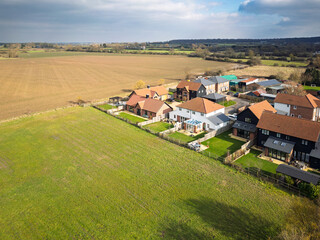 Aerial view of a small estate ofd private houses seen on the edge of rural Essex farmland in the UK. Parcels of land are being sold the housing developers.