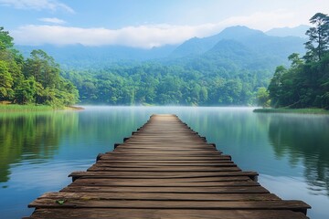 Naklejka premium Serene wooden pier reflecting in calm lake surrounded by mountains 