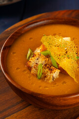Red Lentil Soup with ingredients on wooden background, top view, copy space. Traditional turkish or arabic lentil and vegetable spicy soup, healthy vegan food.