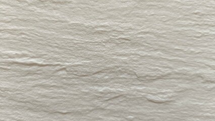 Naklejka premium The rough, stone-like texture of the wall tiles is a multi-patterned, cream-white horizontal wave pattern.