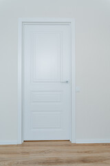 Imagine an empty room adorned with a pristine white door that stands out against the backdrop of a beautifully crafted wooden floor, creating a serene and inviting home atmosphere