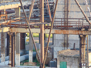 Image depicts an abandoned industrial site, likely a dismantled shipyard or factory Rusty metal...
