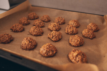 Homemade oatmeal cookies are lying on parchment on a baking sheet. Homemade biscuits. Bakery. Vegetarian food. Healthy breakfast