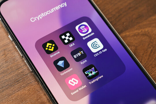 Poznan, Poland - March 12, 2025: cryptocurrency mobile apps folder on smartphone screen with binance okx bybit cex io sweatcoin tonkeeper tradingview and sweat wallet icons