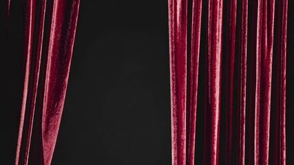 A close-up video of rich red velvet curtains, partially open, with a dramatic and elegant style, viewed from a front-facing angle. Live desktop wallpaper.