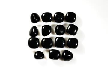 Polished Black Natural Onyx Gemstones Arranged in Grid Pattern on White Background