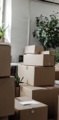 A modern office with several cardboard boxes stacked on a desk, green plants and office furniture in the background