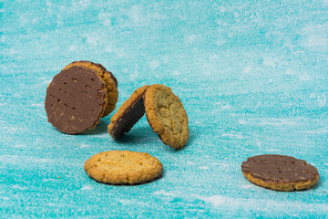 Golden-brown cookies are spread out on a blue background. Their homemade appearance evokes warmth, sweetness, and indulgence, making it perfect for dessert and baking themes.
