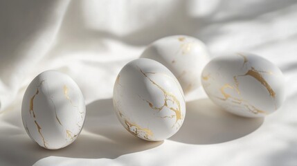 Elegant kintsugi style eggs on silky white fabric in sunlight