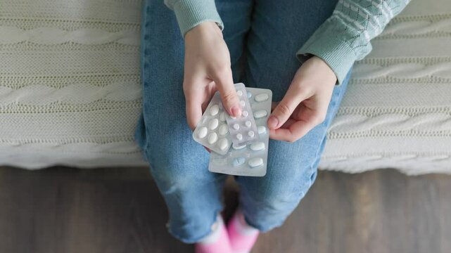 Unrecognizable hands girls hold three blisters with different pills, from different diseases.