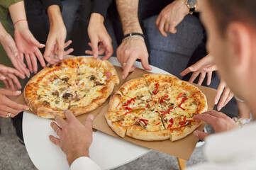 Top view close up hands of a young people friends gathering in pizzeria or at home together eating tasty Italian food taking pizza slices enjoying party indoors. Food delivery concept.