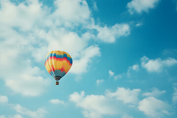 Fototapeta premium Colorful hot air balloon flying in blue sky with clouds