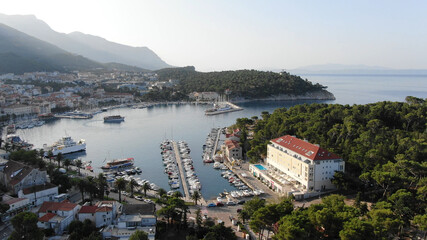 Fototapeta premium A peaceful coastal town wakes up to a golden sunrise, with boats gently floating in the harbor. Perfect for travel marketing, tourism ads, and real estate promotions.Croatia.