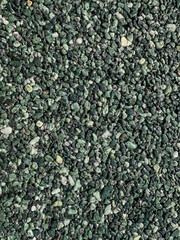 Close up of dark green colored natural stone carpet. Decorative stone coating. Slip resistant floor finish containing natural stone particles