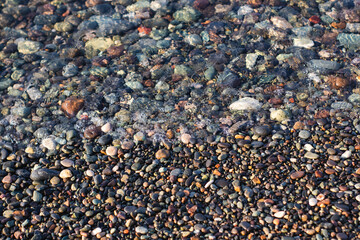 Sea pebbles on the seashore as an abstract background.