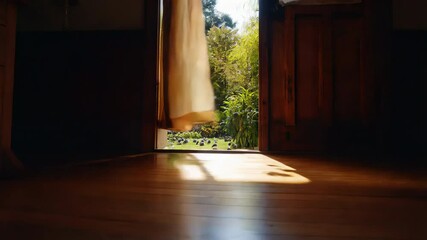 Open doorway with curtains and view of green field lit by low sun. Concept of fresh morning and openness to nature