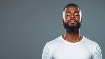 Obraz premium Man with closed eyes and a serene expression on a gray background