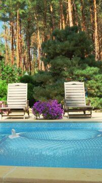 Relaxing by the Pool with Loungers and Inflatable Ring. Sunny Pool Day with Loungers and Inflatable Float. Relaxing Summer Day Vertical video