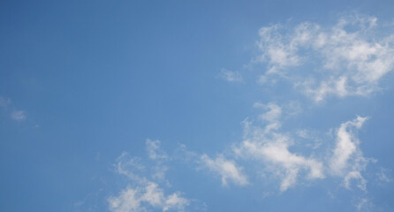 Clear blue sky, sunny day, soft white clouds, ideal peaceful background, weather-related concepts, sunlight shining brightly, calm soothing environment, expansive overhead view in thailand
