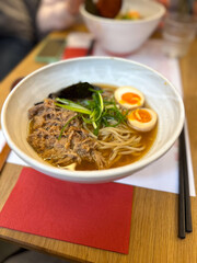 Miso Ramen Asian noodles soup with beef, egg and pak choi cabbage in restaurant