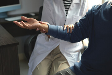 Fototapeta premium Physiotherapist doing physiotherapy for patient in a hospital room, physiotherapy helps to recover from illness by moving the body and muscles. The concept of treating illnesses with physical therapy.