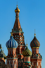 Domes of the Cathedral of the Intercession of the Most Holy Theotokos on the moat on Red Square in Moscow on a sunny day against a blue sky