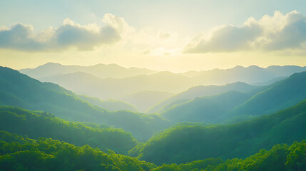 Fototapeta premium Serene sunset over lush green mountain range, showcasing layers of hills bathed in golden light. A peaceful landscape perfect for travel, nature, or environmental themes.