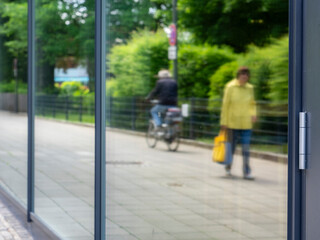 Passanten in der Stadt spiegeln sich in einem Schaufenster