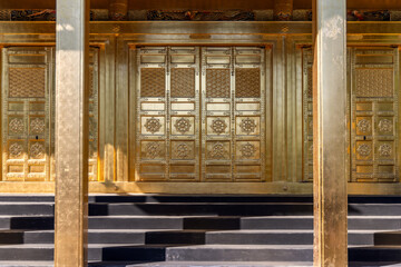 Meticulously crafted golden door featuring elaborate carvings and symmetrical motifs is a focal...