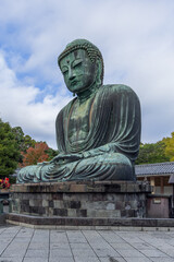 Side view of the Great Buddha statue at Kotoku-in temple in Kamakura Japan showing the aged bronze surface meditative pose and peaceful expression