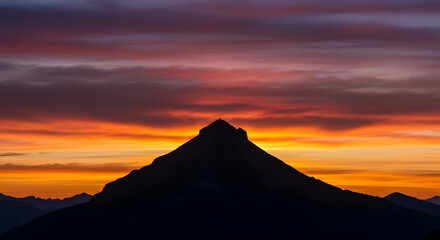 Mountain Silhouette Against a Dramatic Sky at Sunset with Vibrant Colors