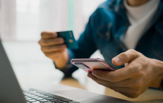 Concept that men use credit cards for online shopping and digital payment through mobile applications and Internet banking.